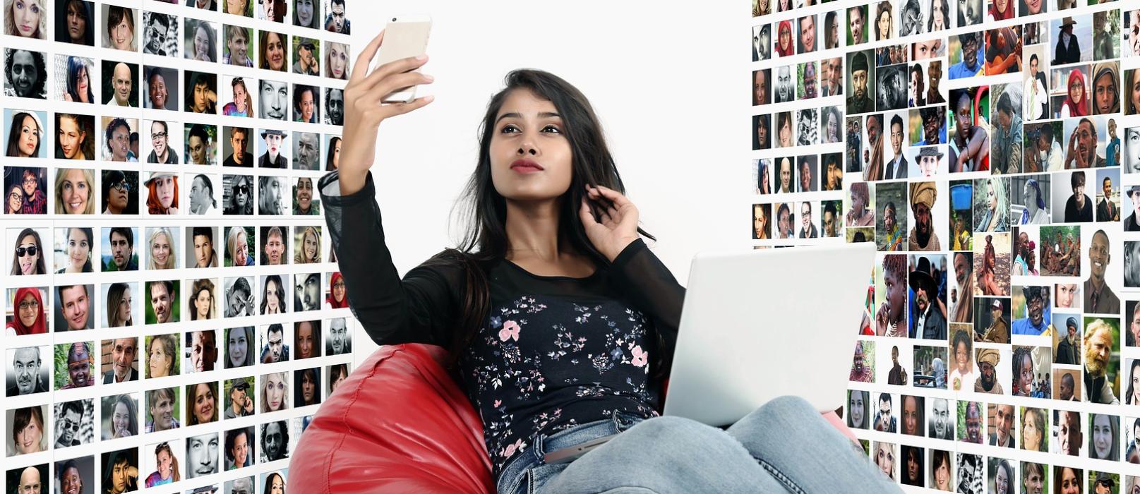 Mädchen sitzend im Sitzsack, welches in ihr Handy schaut, um sie herum sind viele Porträts