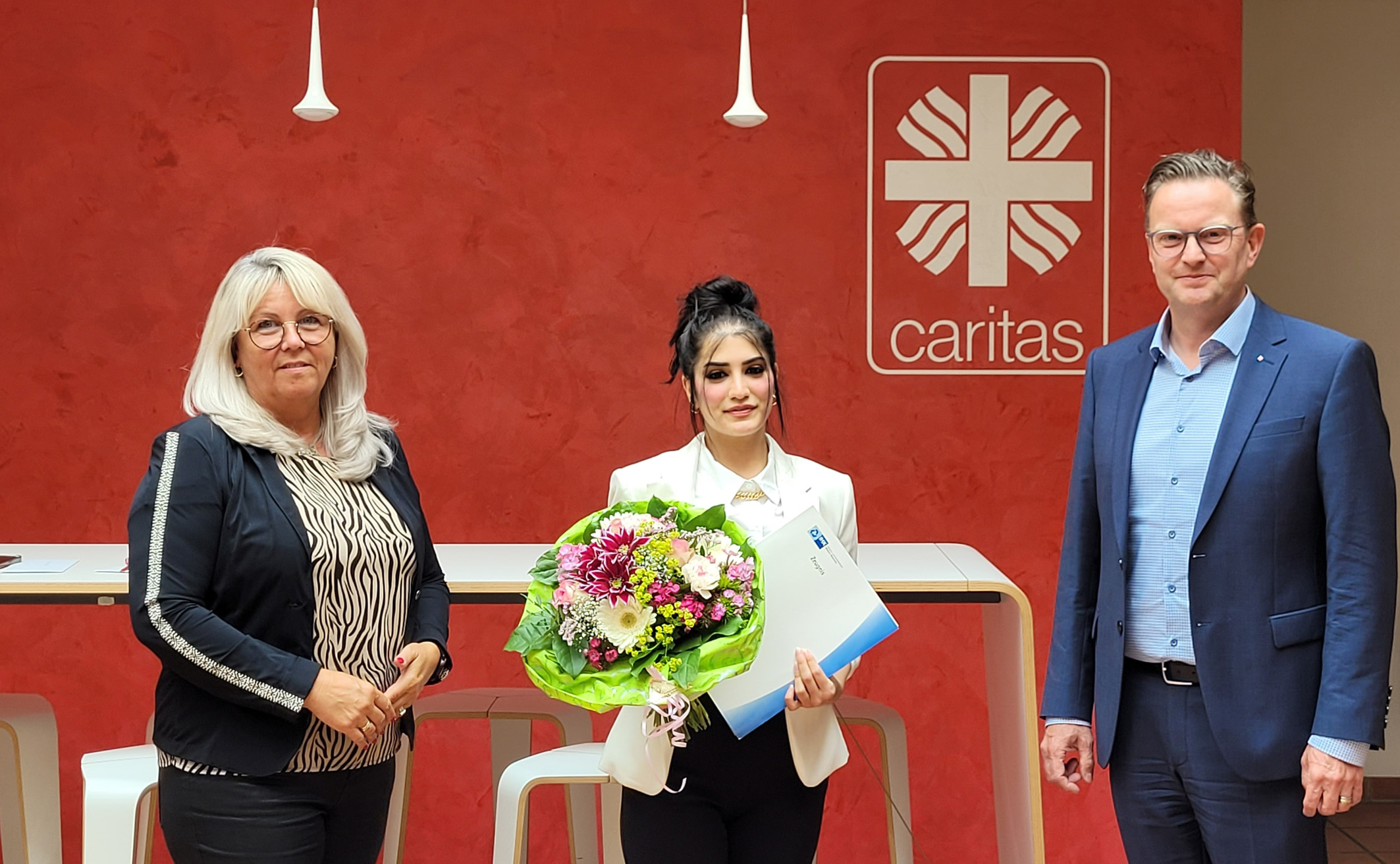 Sie sind stolz auf den erfolgreichen Ausbildungsabschluss von Fatima Aloto (Mitte): Ausbilderin Beate Katschke, Personalmanagement, und Caritas Vorstandsvorsitzender Marc Inderfurth.